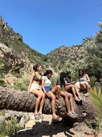 Visitors sitting on rocks beside a natural pool