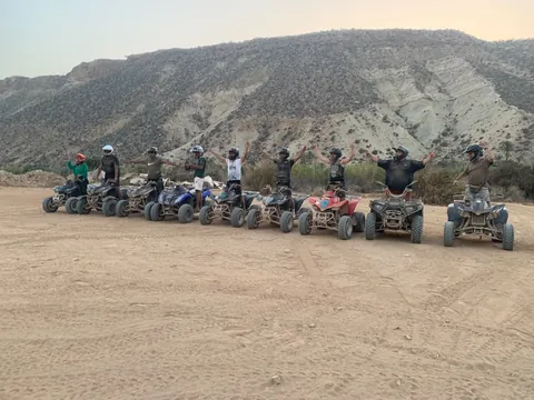 Guests and quad bikes lined up beside a rocky mountain landscape