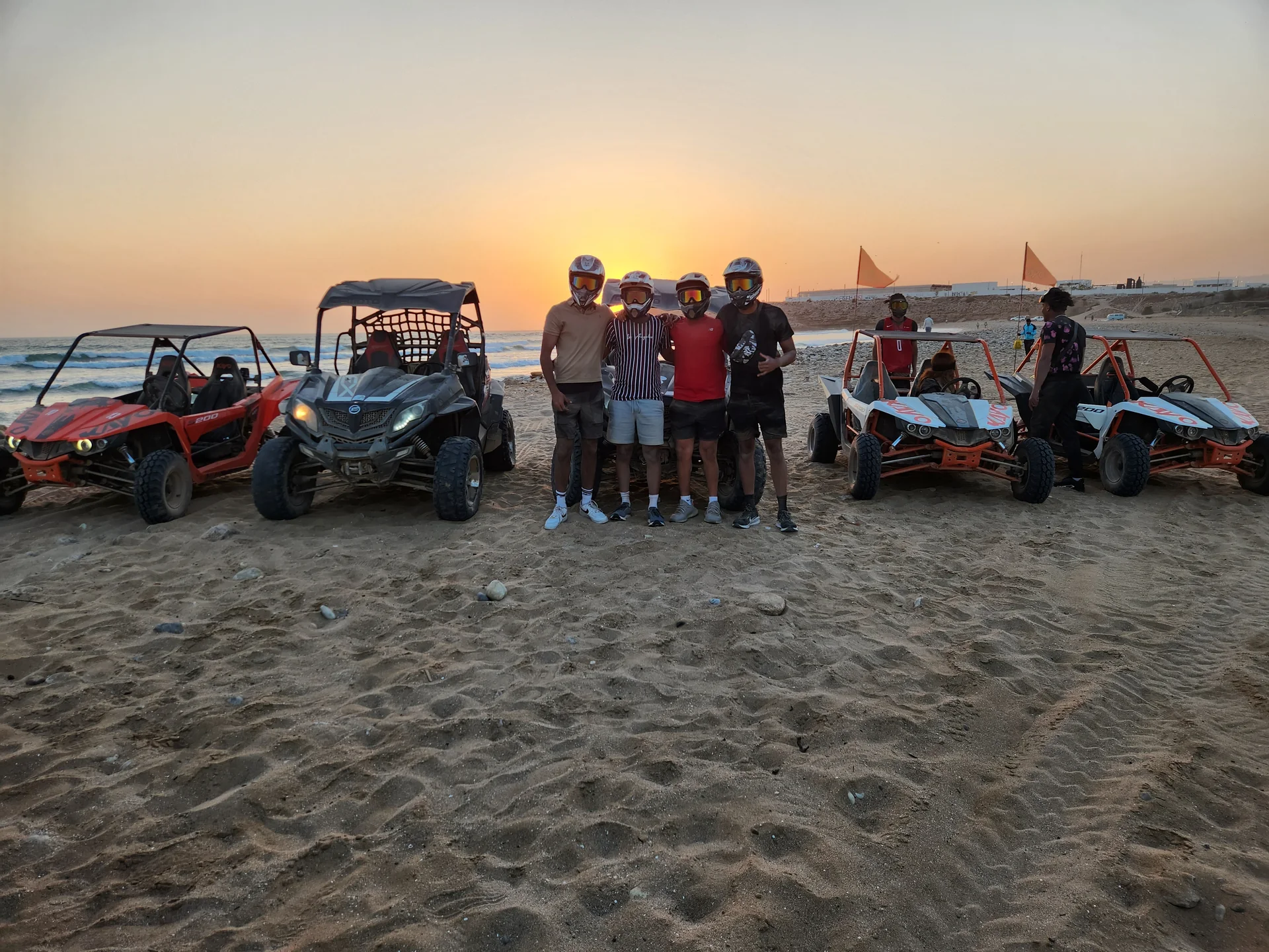 Guests and buggies beside the beach at sunset