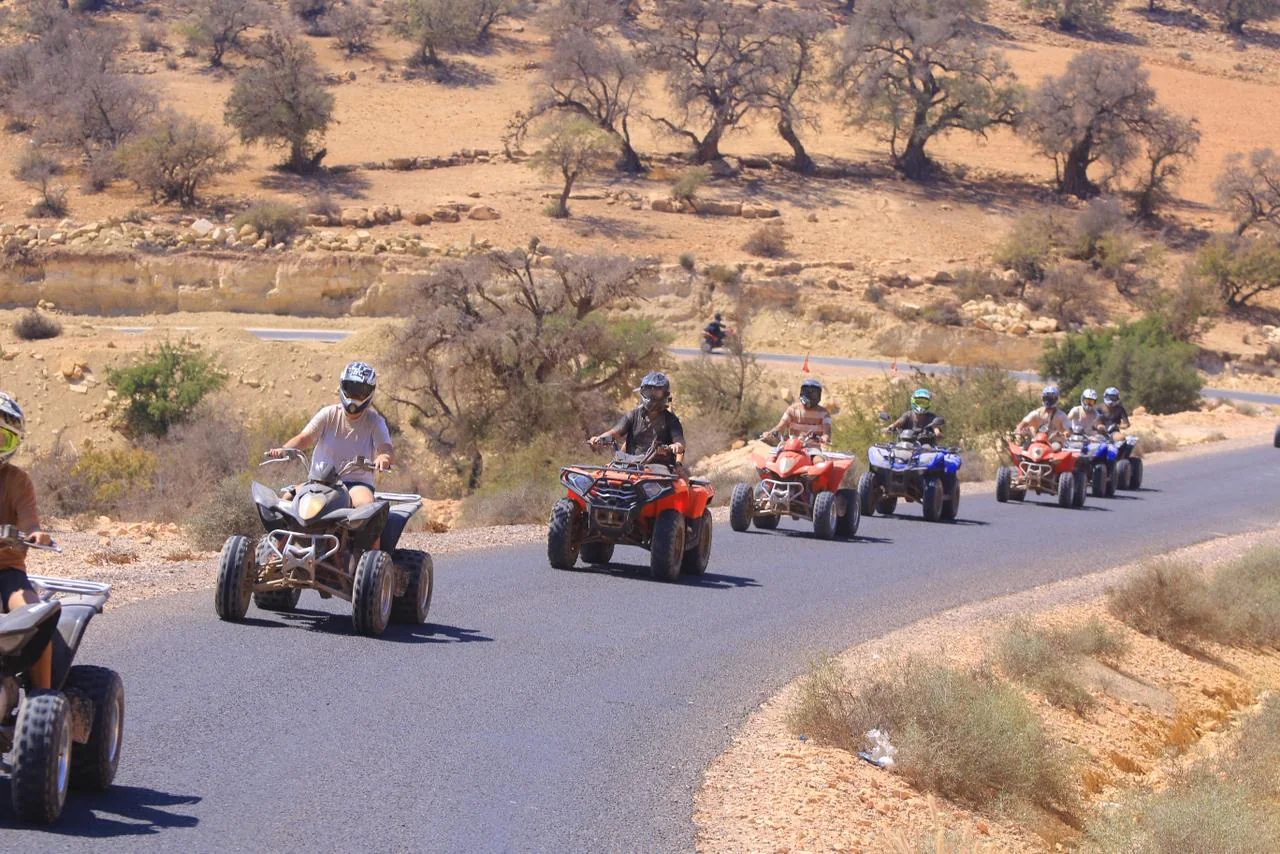 Quad riders following a road through the mountains